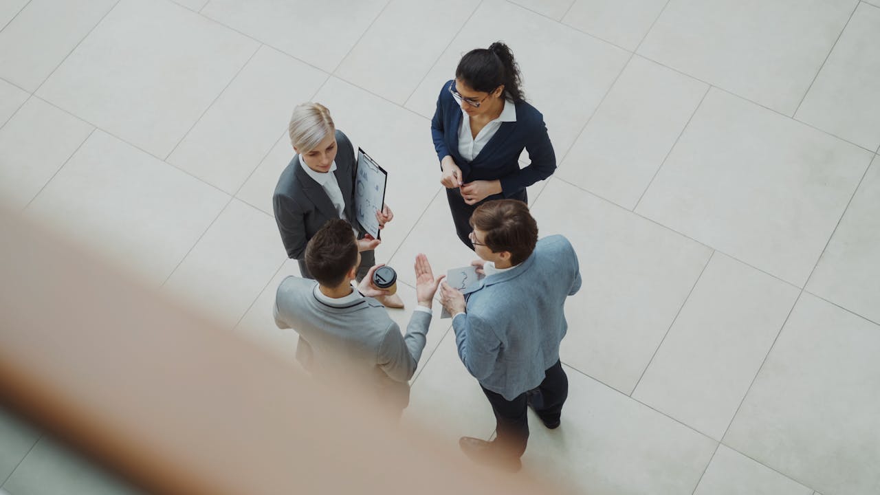home-hero-bg Overhead shot of diverse business team discussing a project indoors.